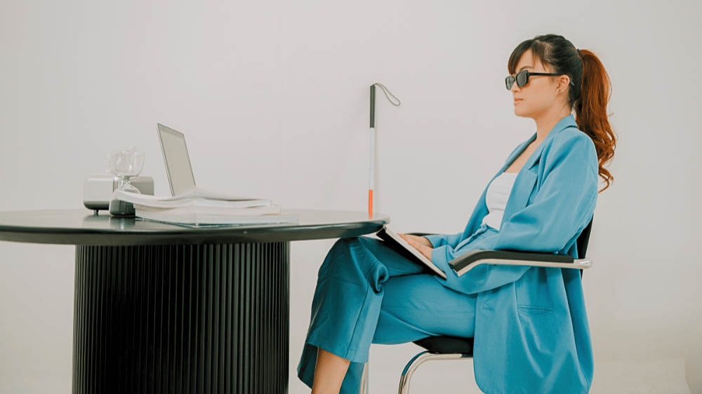 Blind woman sitting at her work desk.