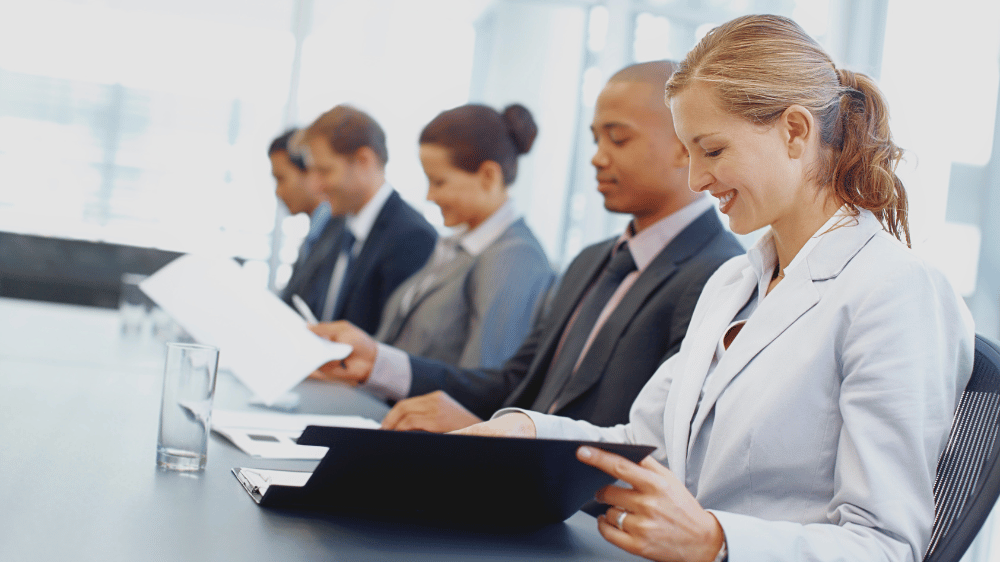 Team members in a meeting opening the meeting agenda portfolio