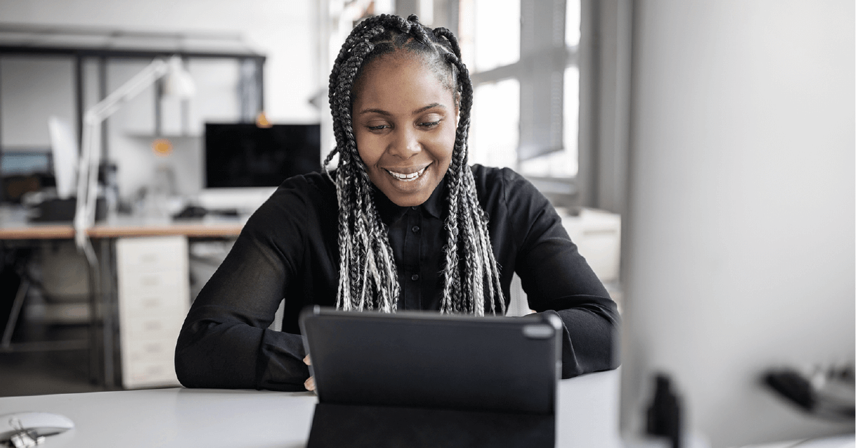 Smiling woman sitting in front of her laptop at work.