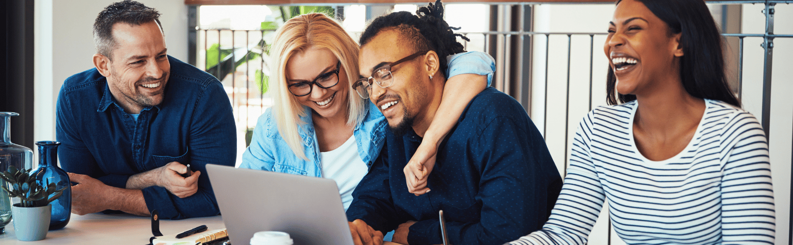 Happy workers huddled around a computer