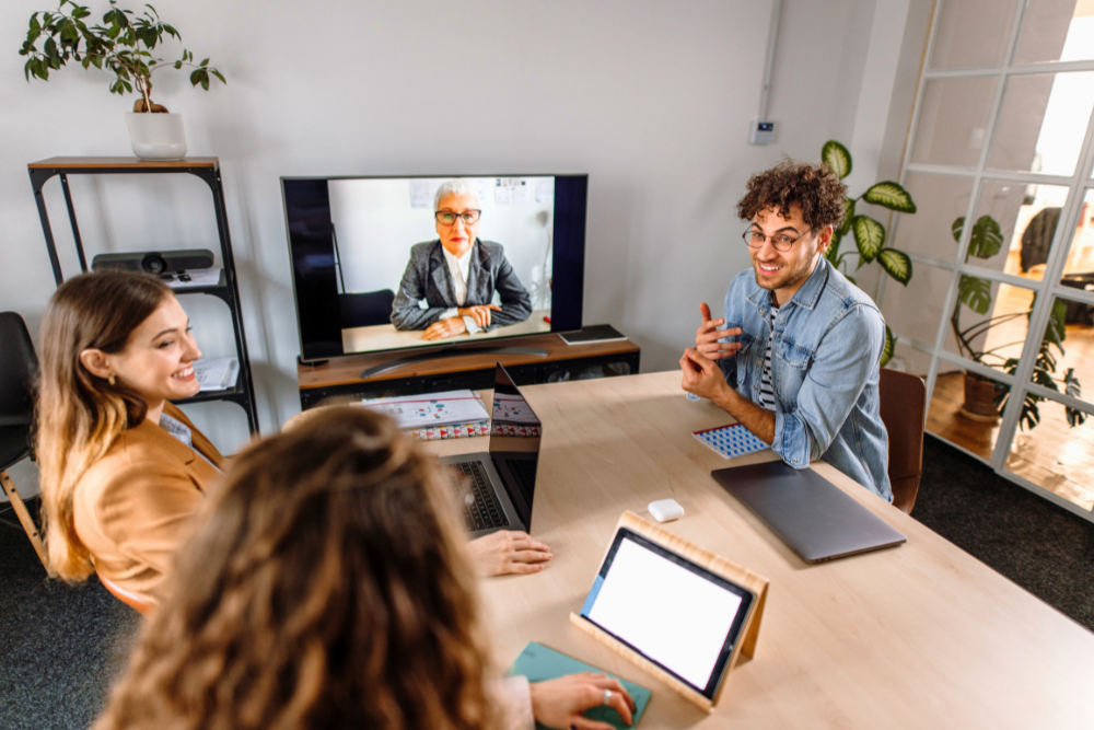 A skilled meeting facilitator guides a hybrid meeting,  ensuring all participants are engaged and contributing effectively.