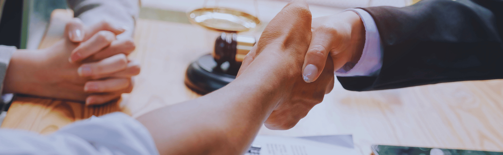 Closeup of coworkers shaking hands after clearing up productive disagreement