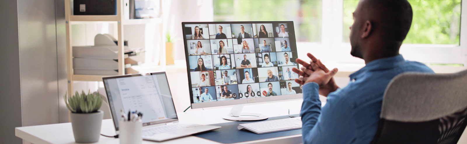 Guy working from home looking at a laptop screen during a virtual meeting